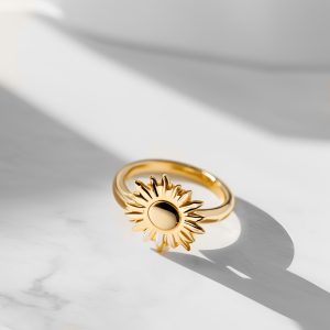 Gold ring with sun on a marble background